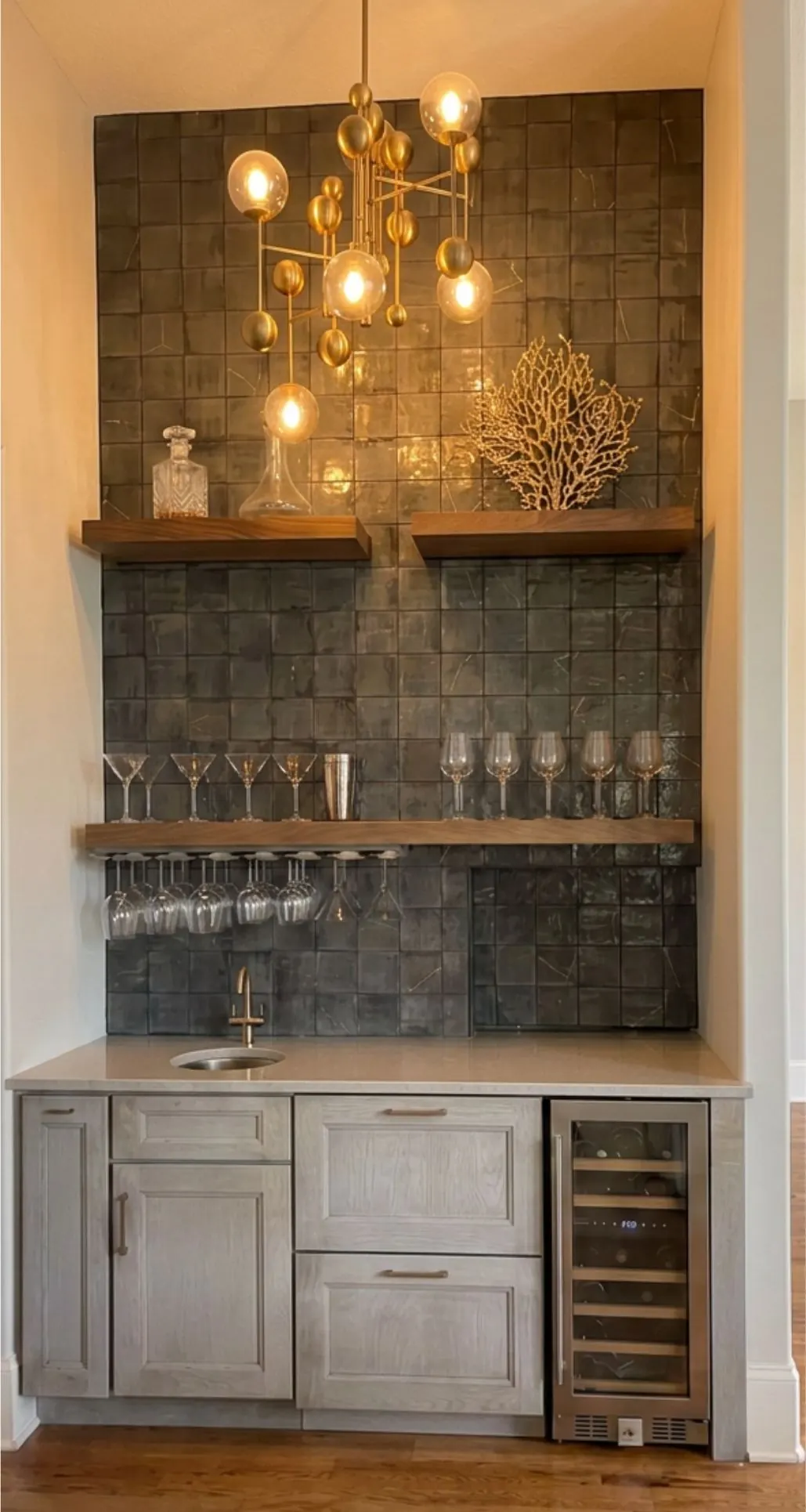 Built-in bar area in Loch Lloyd, MO with glass tile backsplash, open shelving, and wine refrigerator