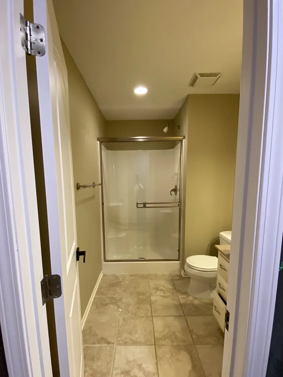 Original fiberglass shower insert behind sliding glass doors before the remodel, Kansas City, MO
