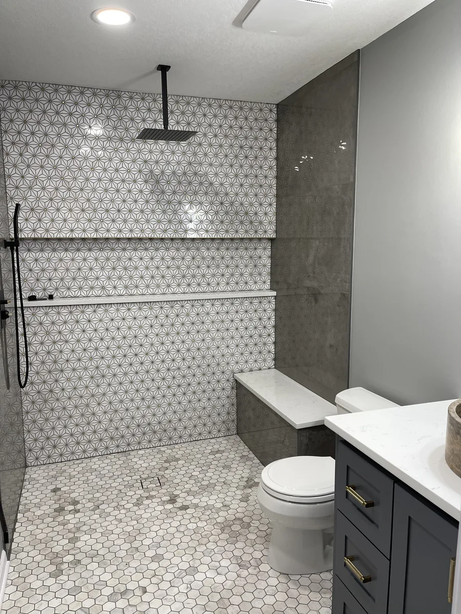 Finished zero-entry shower with marble hexagon floor, star-pattern mosaic accent wall, and built-in bench, Kansas City, MO