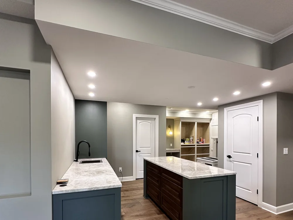 Basement renovation in Lone Jack, MO with custom wet bar, kitchen island, and marble countertop