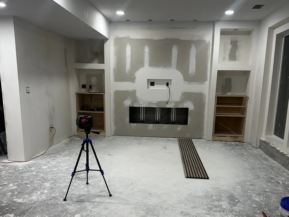 Basement renovation in Lone Jack, MO — media wall under construction with framed fireplace opening