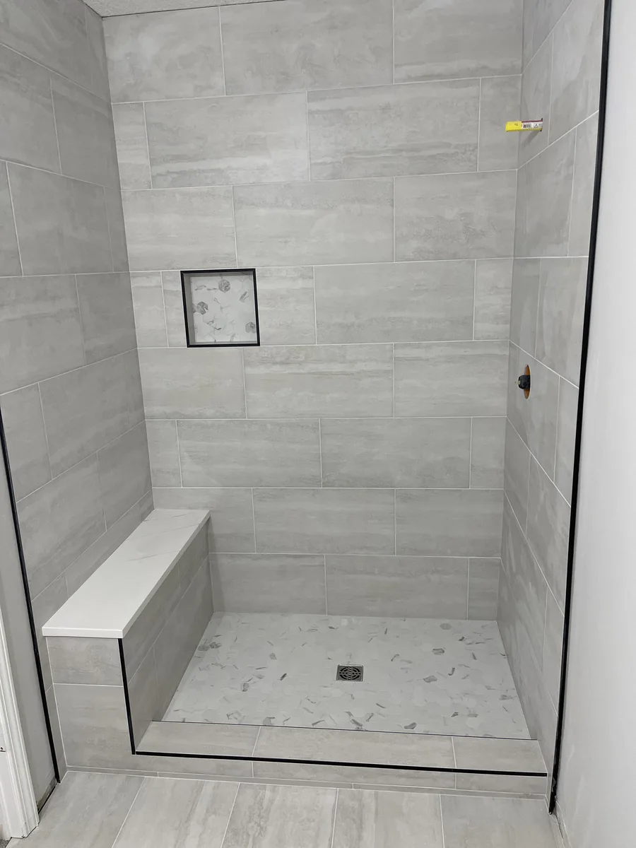 Whole-home remodel in North Kansas City, MO — finished bathroom shower with built-in bench and tiled niche