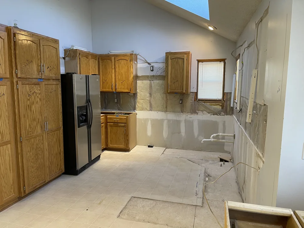 Whole-home remodel in North Kansas City, MO — kitchen demolition down to studs with vaulted skylight ceiling exposed