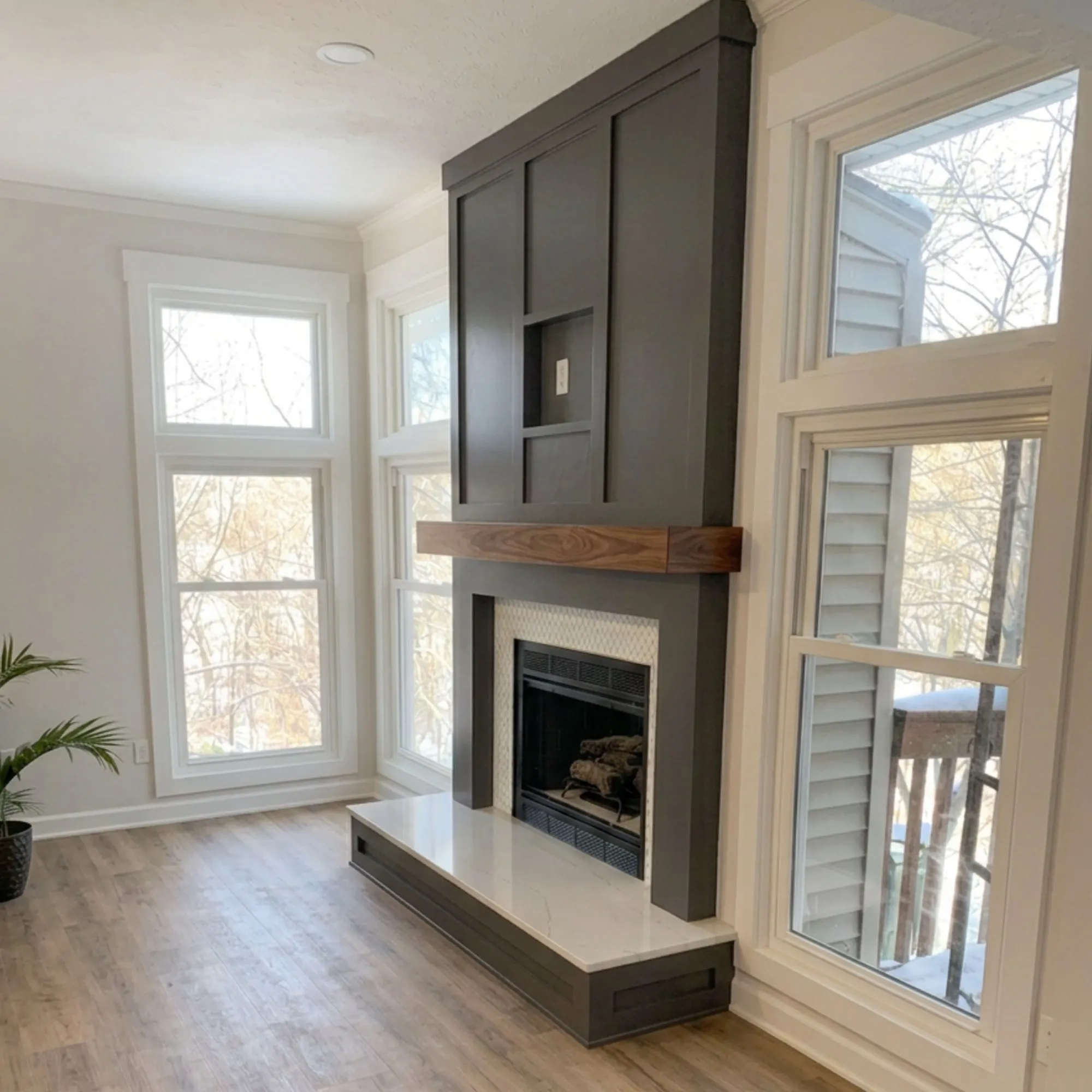Living room fireplace in Blue Springs, MO with dark wood surround, walnut mantel, and marble hearth