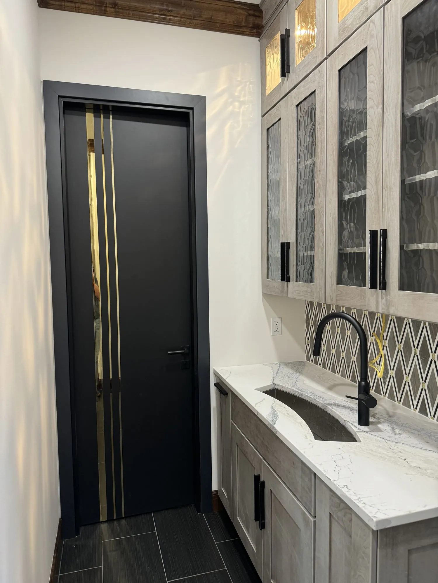Wet bar remodel in Lenexa, KS with glass cabinetry and brass-inlay door